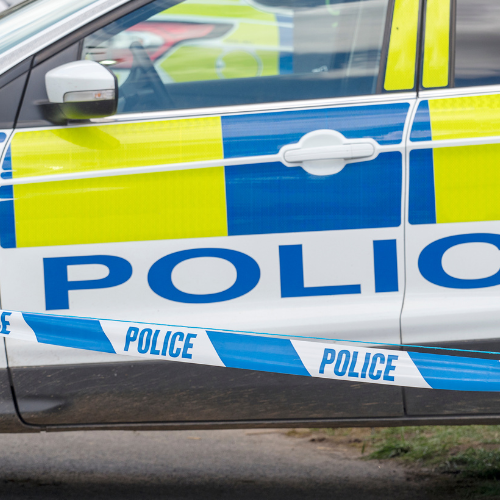 Image showing a police car with police tape.